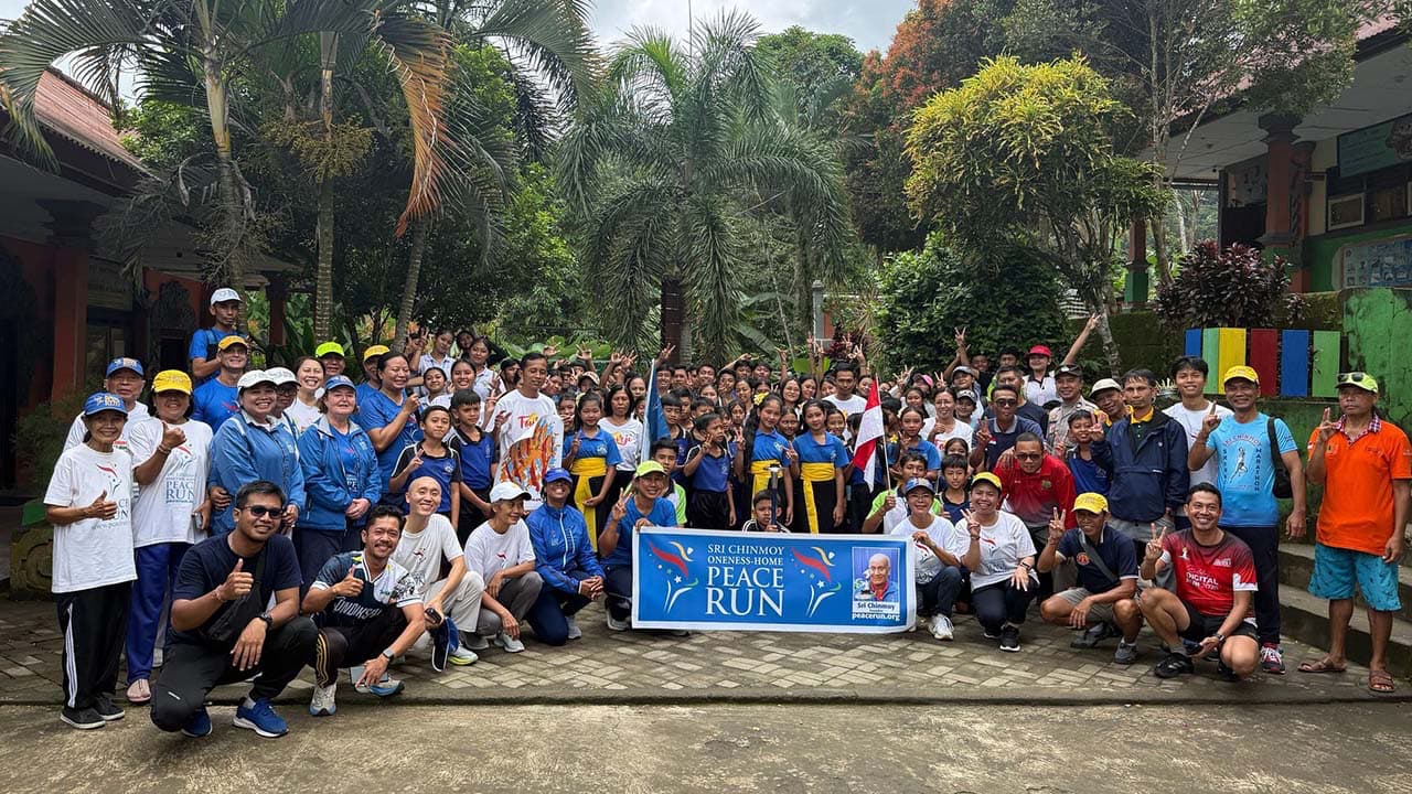 Students welcoming the First Peace Run Bali 2026 team in Sudaji village with banners and smiles.