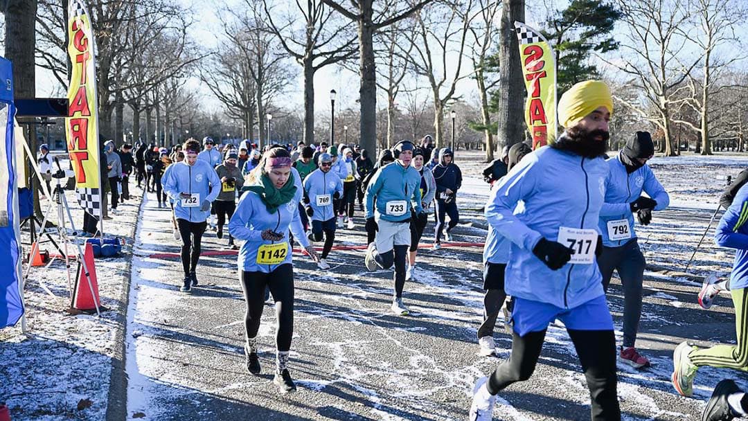 Runners starting the New Year's Day Half-Marathon 2026 in Flushing Meadows Corona Park, capturing the excitement of the New Year kickoff.